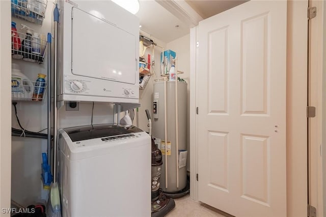 clothes washing area featuring stacked washer / dryer and water heater