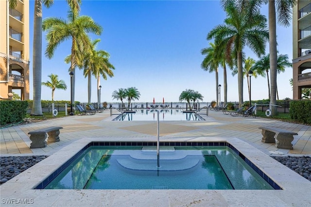 view of swimming pool with a patio area and a water view