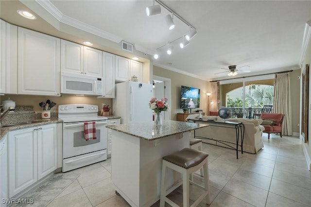 kitchen with light stone countertops, white appliances, white cabinetry, and sink