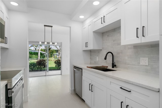 kitchen with white cabinetry, stainless steel appliances, tasteful backsplash, hanging light fixtures, and sink