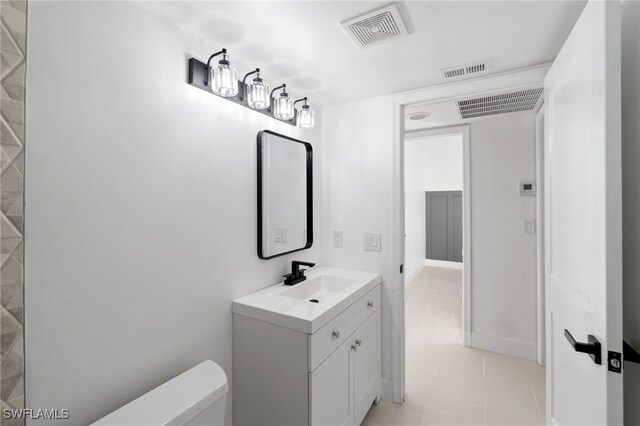 bathroom with toilet, tile patterned floors, and vanity