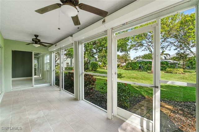 unfurnished sunroom with ceiling fan