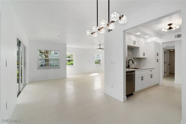 kitchen with white cabinets, dishwasher, decorative light fixtures, sink, and backsplash