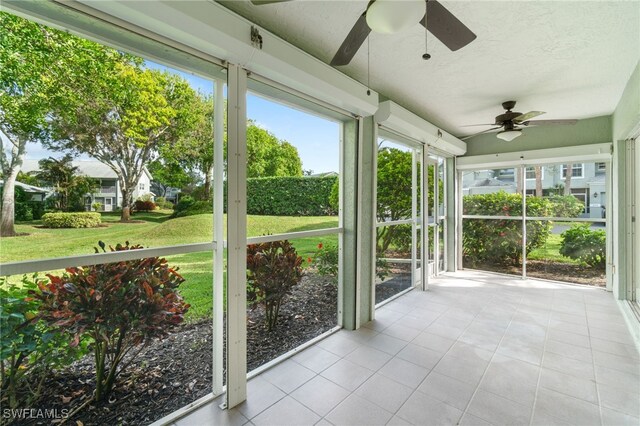 unfurnished sunroom with ceiling fan