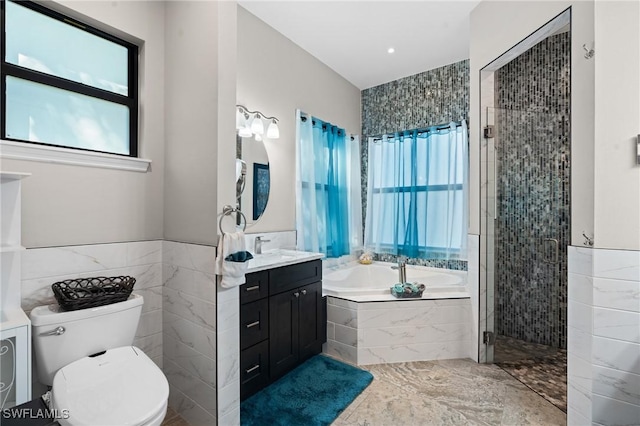 full bathroom with a garden tub, plenty of natural light, tile walls, and vanity