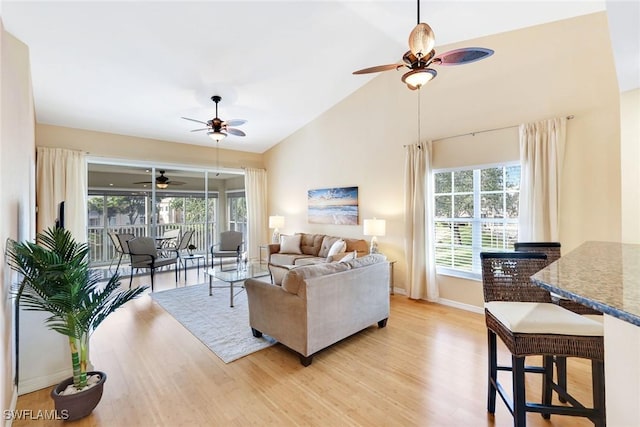 living room with vaulted ceiling, light hardwood / wood-style floors, and ceiling fan