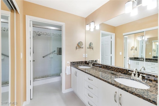 bathroom with tile patterned flooring, vanity, toilet, and walk in shower