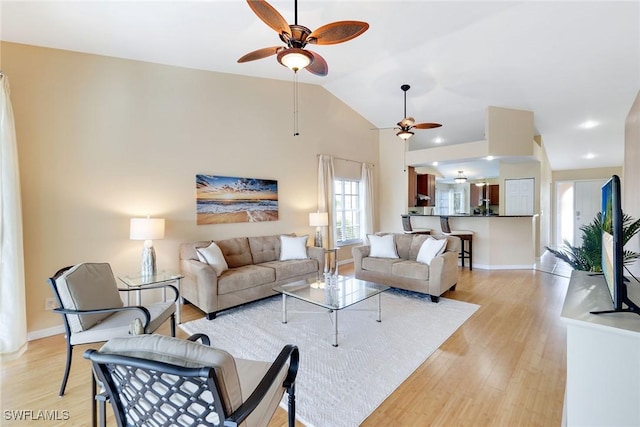 living room featuring ceiling fan, vaulted ceiling, and light hardwood / wood-style flooring