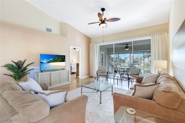 living room featuring lofted ceiling, ceiling fan, and light wood-type flooring