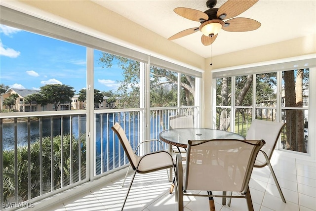 sunroom featuring a water view and ceiling fan