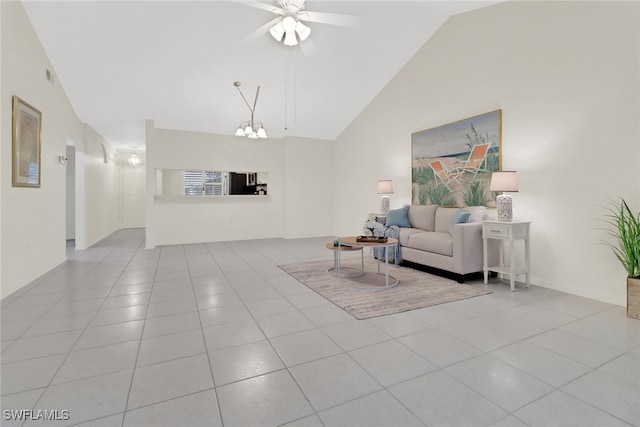 living room with light tile patterned floors, ceiling fan with notable chandelier, and high vaulted ceiling