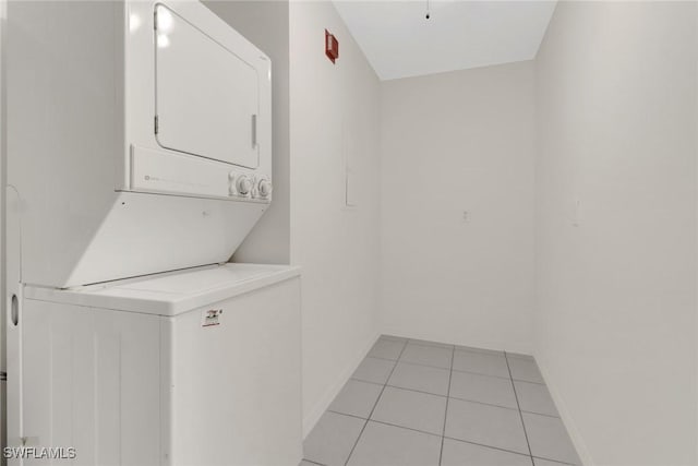 laundry area with light tile patterned flooring and stacked washer / drying machine