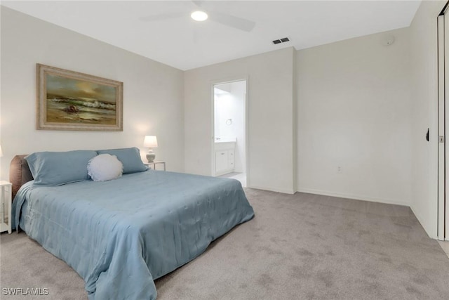 bedroom featuring light carpet, ceiling fan, and ensuite bathroom