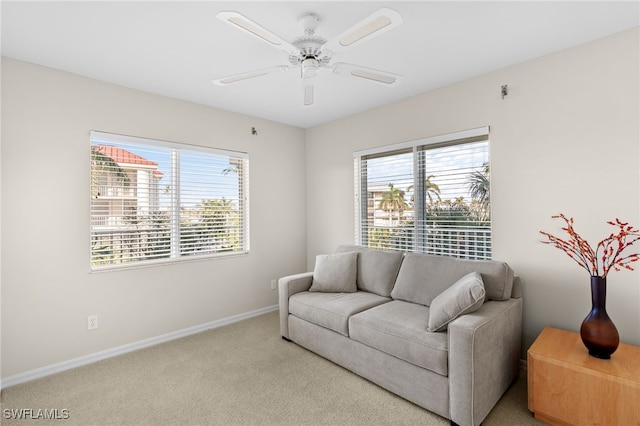 living room with light colored carpet, a wealth of natural light, and ceiling fan