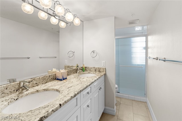 bathroom with tile patterned flooring, vanity, a shower with door, and toilet