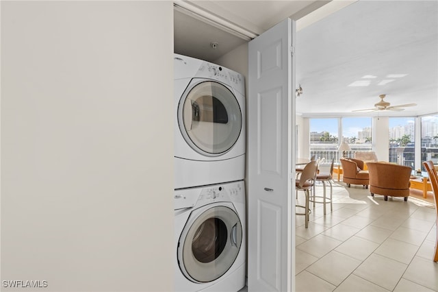 laundry area with light tile patterned floors, ceiling fan, and stacked washer / drying machine