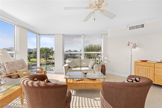 living room featuring ceiling fan, a water view, ornamental molding, and light tile patterned floors