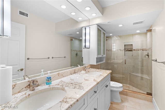 bathroom with tile patterned floors, vanity, toilet, and a shower with door