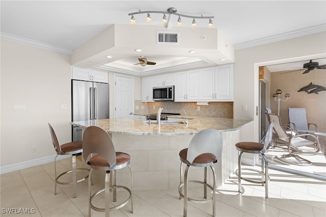 kitchen featuring stainless steel appliances, white cabinetry, and crown molding