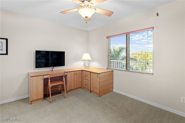 unfurnished office with ceiling fan and light colored carpet