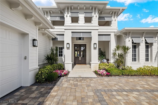 view of exterior entry with french doors and a garage