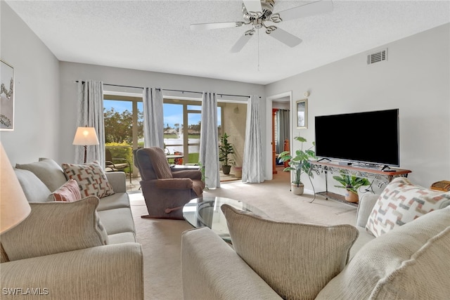 living room featuring carpet, a textured ceiling, and ceiling fan