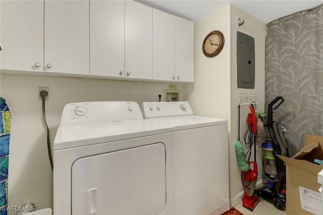 clothes washing area with washer and clothes dryer, cabinets, and electric panel