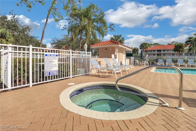 view of swimming pool featuring a community hot tub and a patio