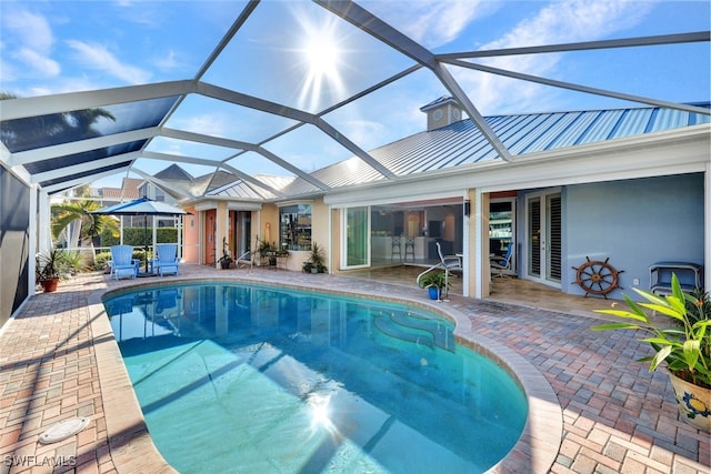 view of swimming pool with glass enclosure and a patio area