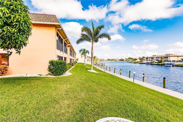 view of yard featuring a water view and a dock