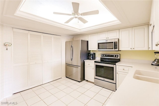 kitchen with a tray ceiling, white cabinetry, ceiling fan, and appliances with stainless steel finishes