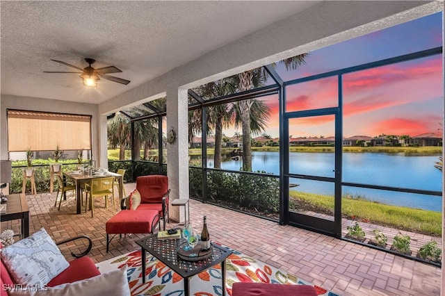 sunroom / solarium with a water view and ceiling fan