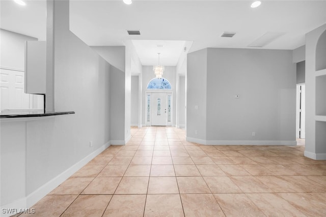 interior space with light tile patterned flooring and an inviting chandelier