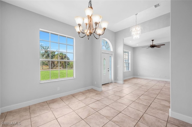 entryway with light tile patterned floors and ceiling fan with notable chandelier