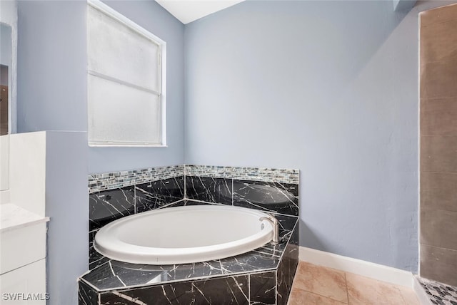 bathroom featuring tiled bath, tile patterned flooring, and vanity