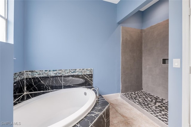 bathroom with tile patterned flooring and a relaxing tiled tub