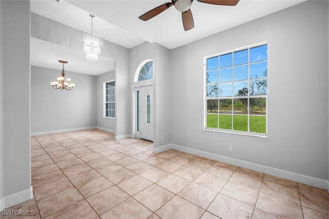 tiled foyer entrance with ceiling fan with notable chandelier