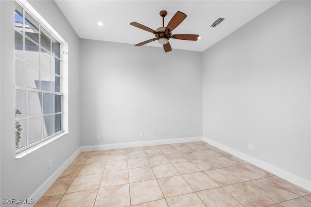 empty room featuring light tile patterned floors, ceiling fan, and a healthy amount of sunlight