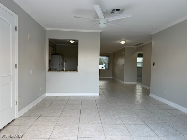 tiled empty room featuring ceiling fan and ornamental molding