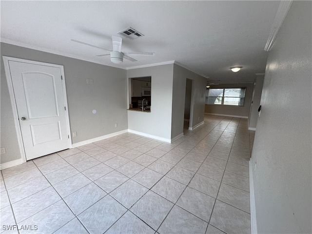 spare room featuring light tile patterned floors, ceiling fan, and crown molding