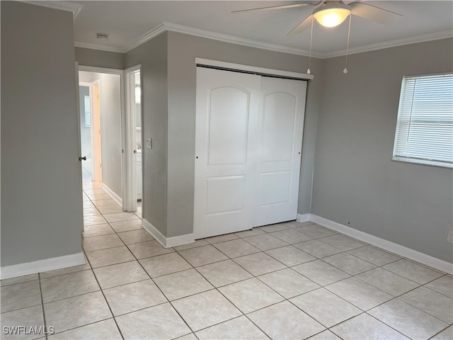 unfurnished bedroom with ceiling fan, ornamental molding, light tile patterned floors, and a closet