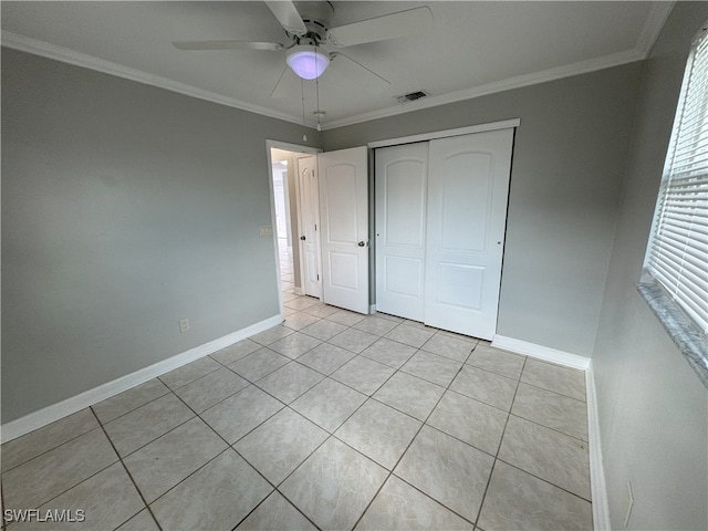 unfurnished bedroom with light tile patterned floors, a closet, crown molding, and ceiling fan