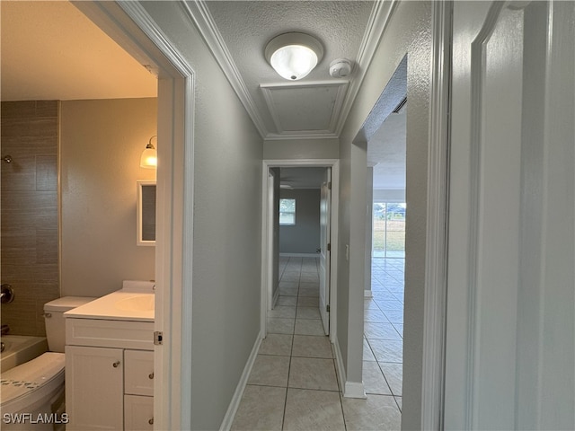 hall featuring crown molding, sink, light tile patterned flooring, and a textured ceiling