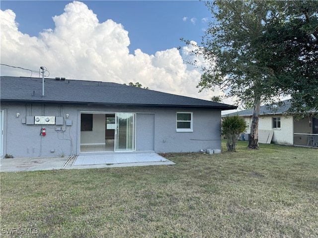 back of property with a patio area and a lawn