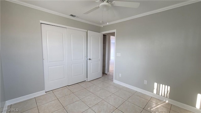 unfurnished bedroom with ceiling fan, light tile patterned flooring, crown molding, and a closet