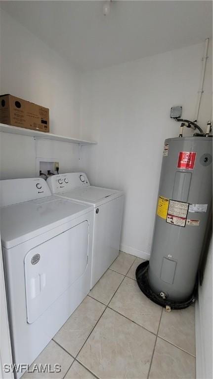 clothes washing area featuring electric water heater, light tile patterned floors, and independent washer and dryer