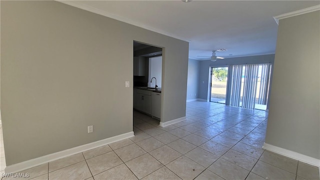 tiled empty room featuring ceiling fan, ornamental molding, and sink