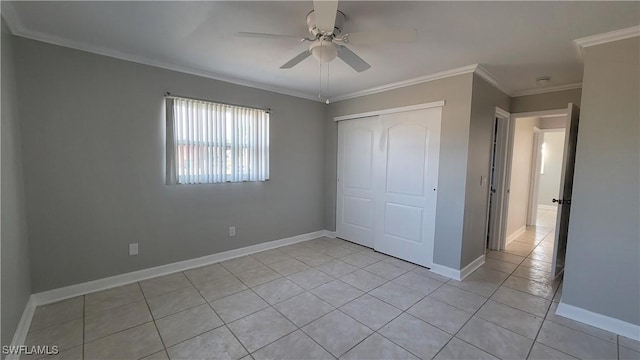 unfurnished bedroom with ceiling fan, a closet, light tile patterned floors, and ornamental molding