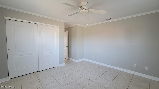 unfurnished bedroom with ceiling fan, a closet, light tile patterned flooring, and crown molding