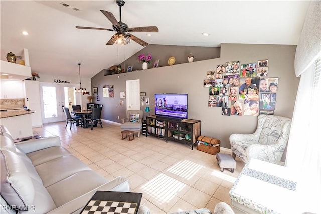 living room with ceiling fan, lofted ceiling, and light tile patterned flooring